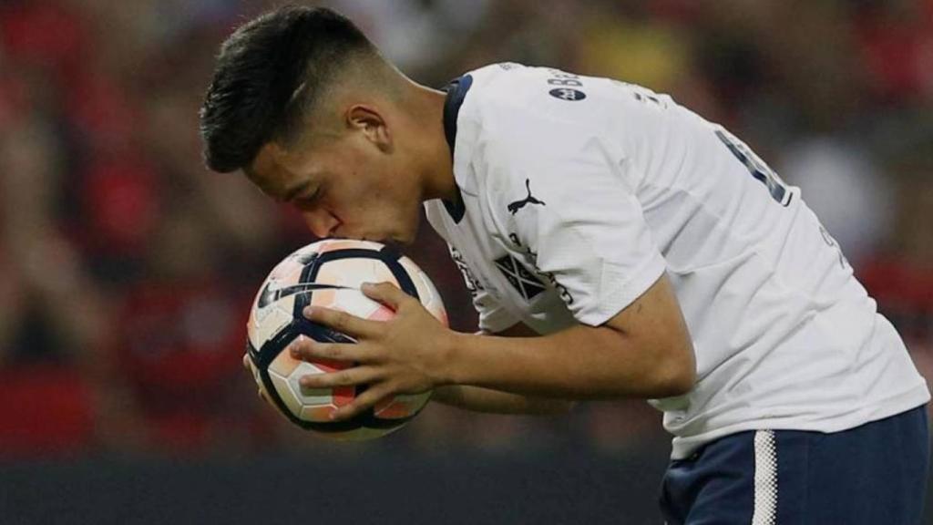 Un jugador besa el balón en un partido de la Copa Libertadores