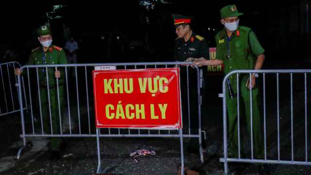 La policía y los soldados eliminan las barreras cuando se levanta la cuarentena en la aldea de Dong Cuu.