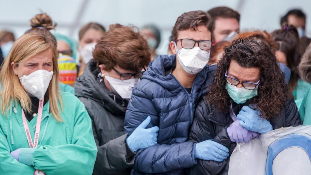 Los sanitarios y compañeros de Esteban Peñarrubia consuelan a su mujer e hijo ante el Hospital Severo Ochoa.