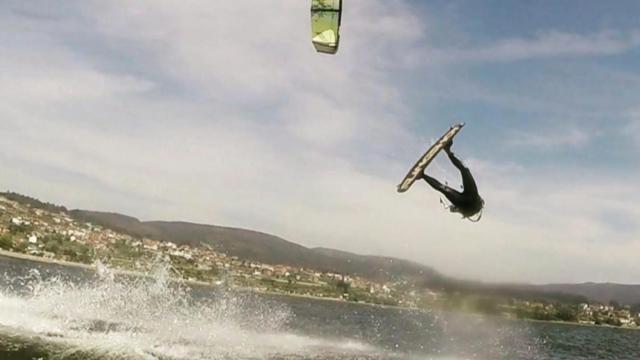 Un deportista practicando kitesurf en una playa gallega.