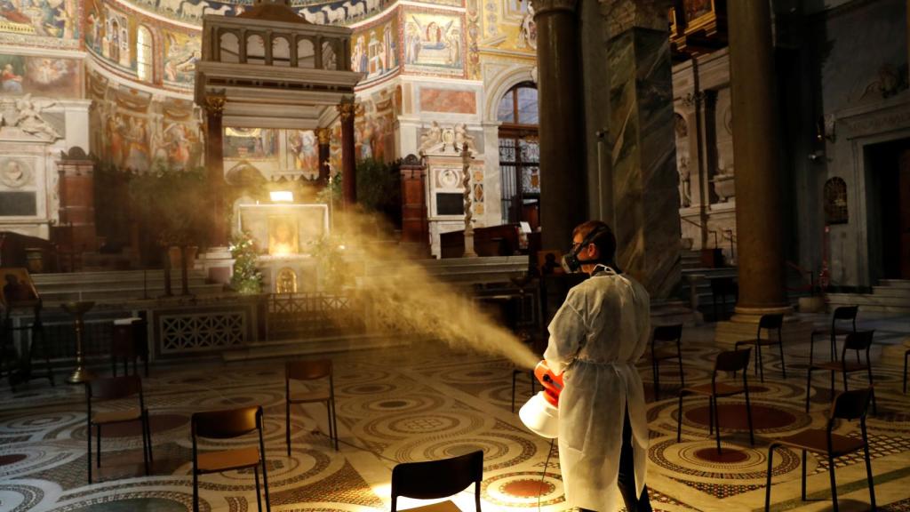 Un cura desinfecta la Basílica de Santa María en Trastevere, Roma.