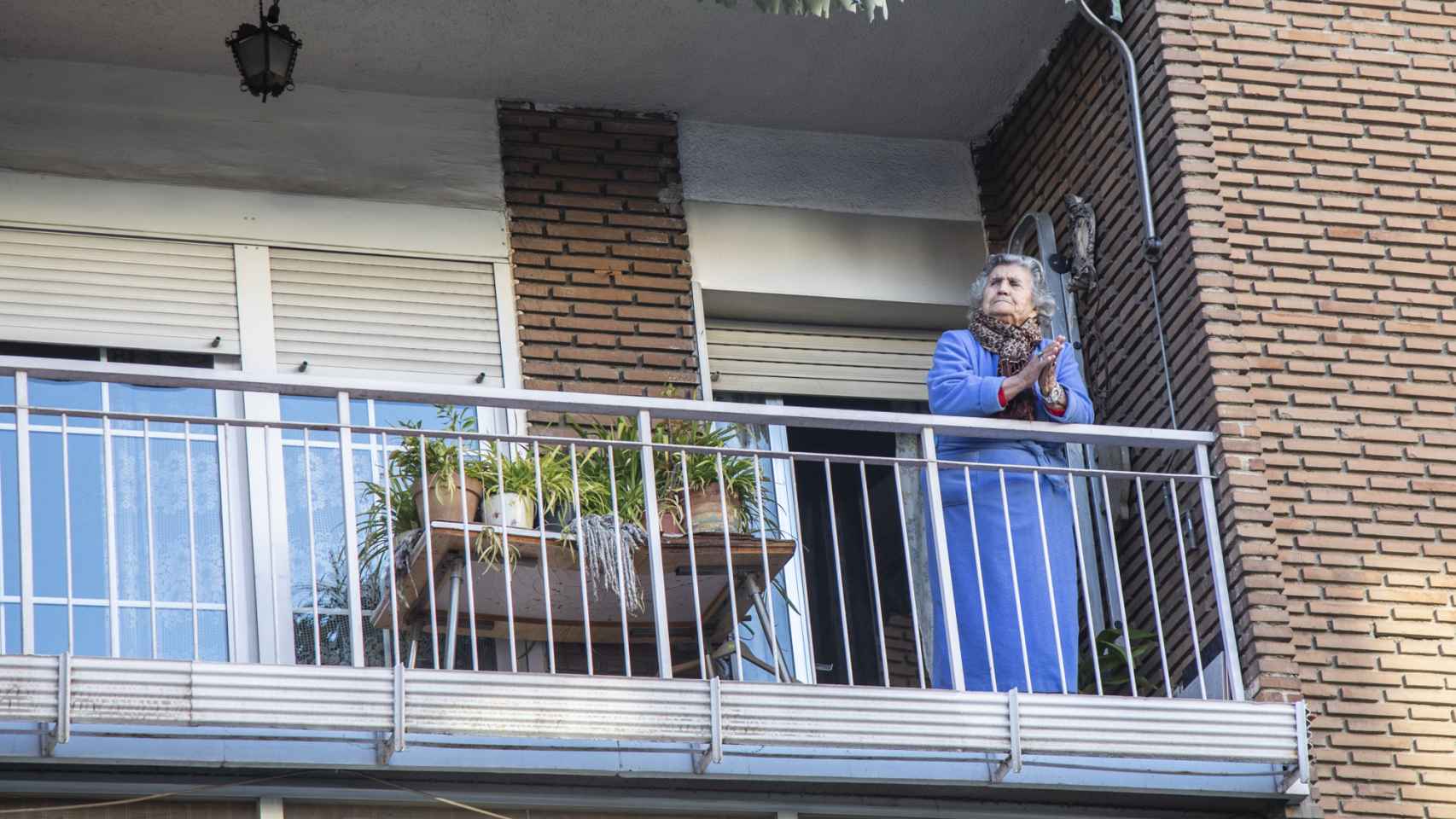 Una mujer aplaude desde su balcón a los sanitarios durante el confinamiento.