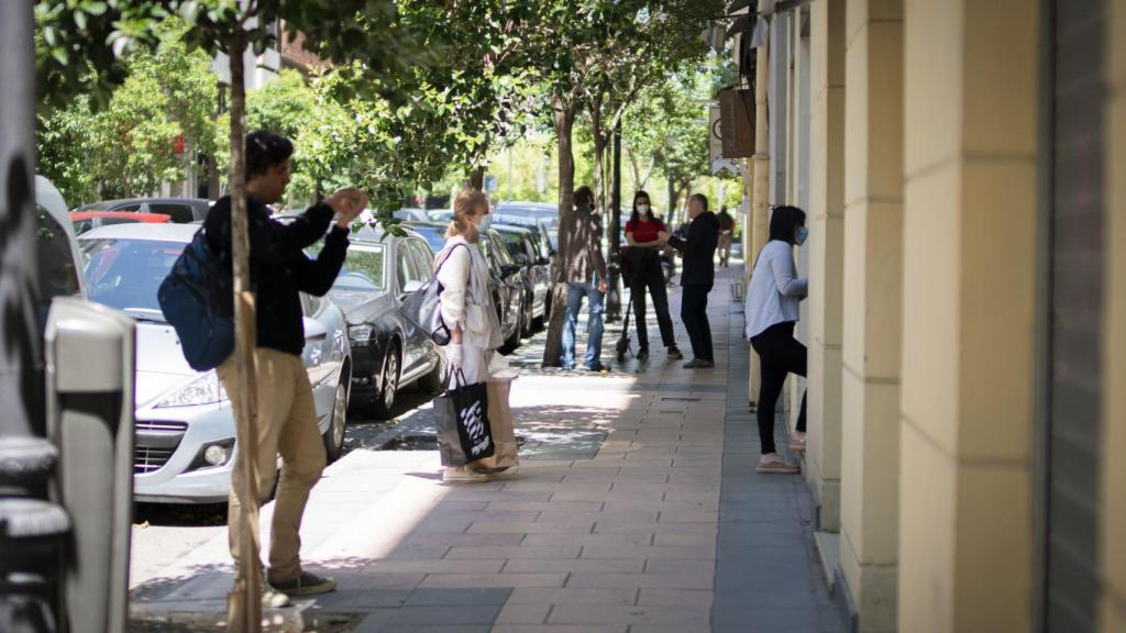 Clientes esperando, pacientemente, a las afueras de una ferretería.