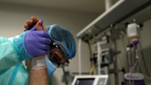 Un médico atiende a un paciente en la UCI de un hospital.