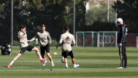 Fede Valverde, Toni Kroos y Marco Asensio disputan un balón bajo la mirada de Zidane