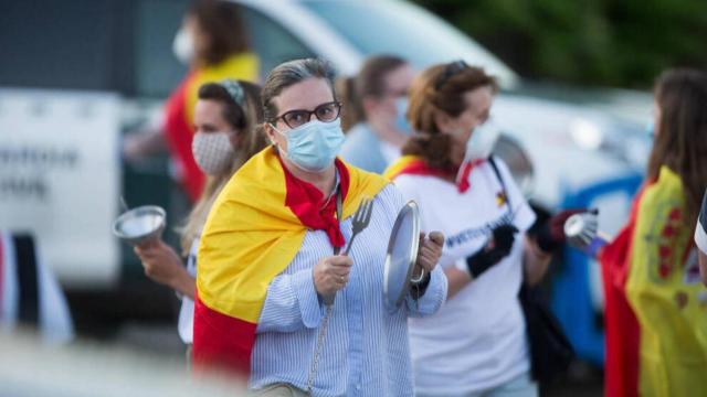 Varias personas golpean cacerolas en señal de protesta con banderas de España por las inmediaciones del cordón establecido por la Guardia Civil en un perímetro de varias manzanas alrededor de la vivienda del vicepresidente del Gobierno de España, Pablo Iglesias. Foto: EP