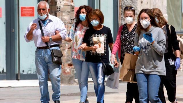 Un grupo de personas haciendo uso de la mascarilla obligatoria, pero con poca distancia social.