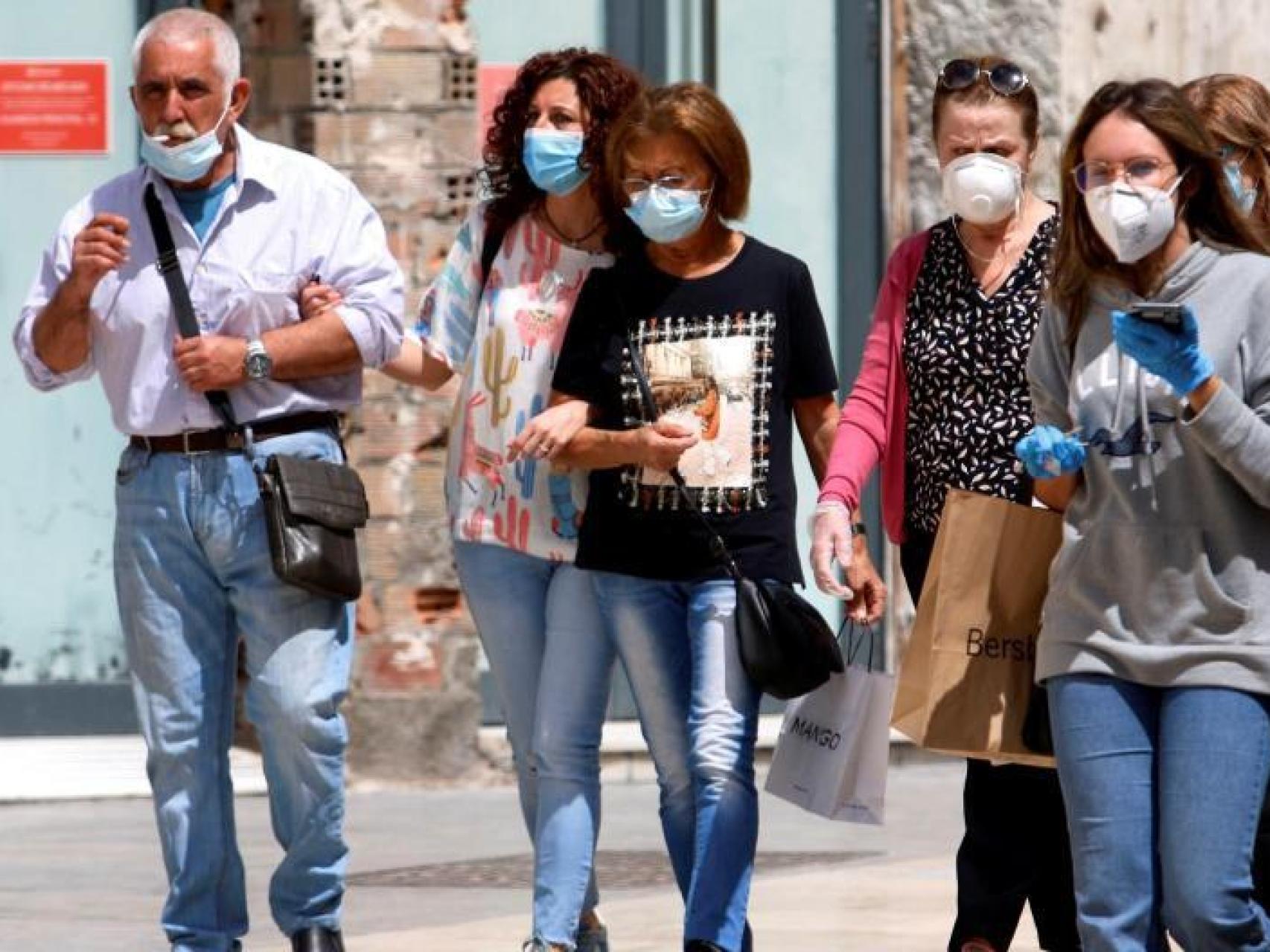 Un grupo de personas haciendo uso de la mascarilla obligatoria, pero con poca distancia social.