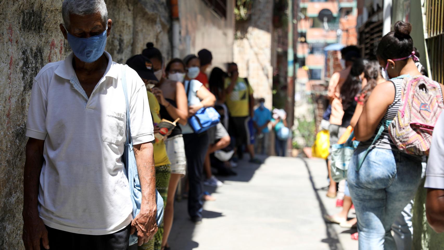 Decenas de personas hace cola para recibir comida de organizaciones caritativas en Carapita, Caracas.