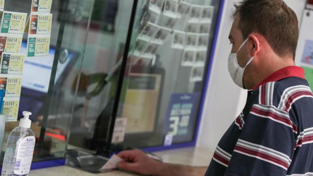 Un hombre comprando en una administración de Loterías y Apuestas del Estado en Valencia.