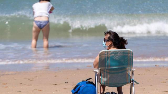 Una mujer con mascarillas en la playa de San Fernando, en Cádiz.