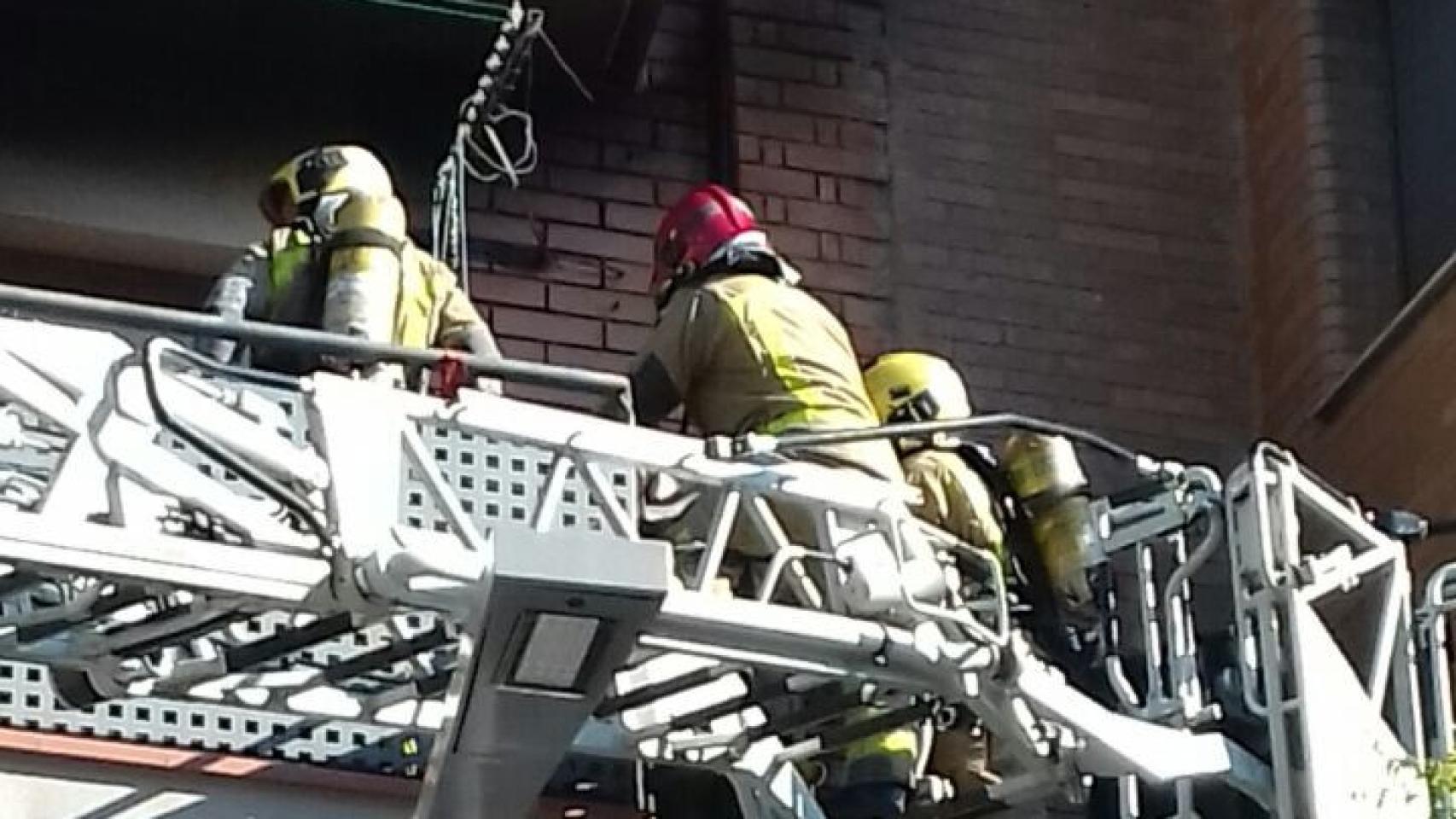 Los Bomberos de la Generalitat, accediendo al piso incendiado en Santa Coloma de Gramenet.