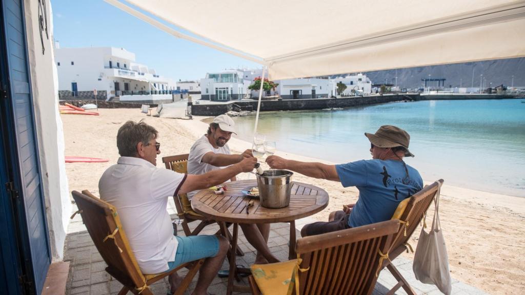 Unos hombres celebran el paso a la fase III en La Graciosa.