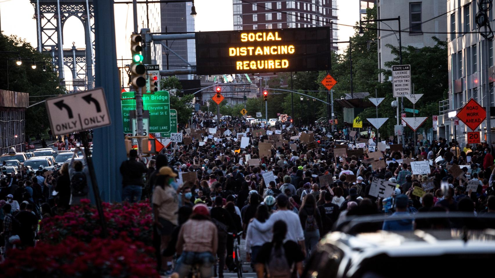 Marcha en Nueva York. Los paneles luminosos instan al distanciamiento social.