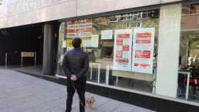 Un hombre pasa con su perro frente a una oficina de Empleo de Madrid.