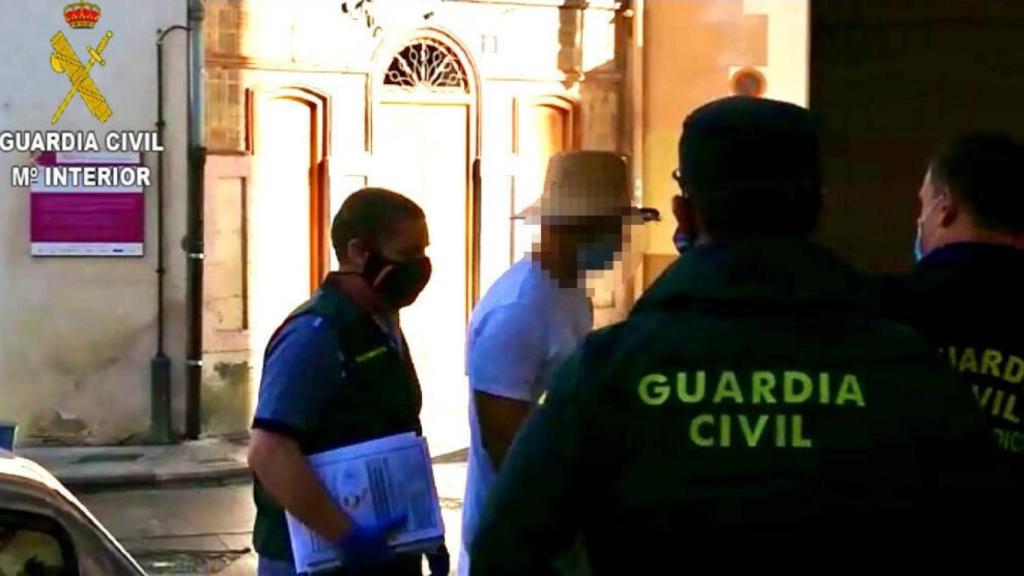 Agentes de la Guardia Civil acompañan a uno de los detenidos