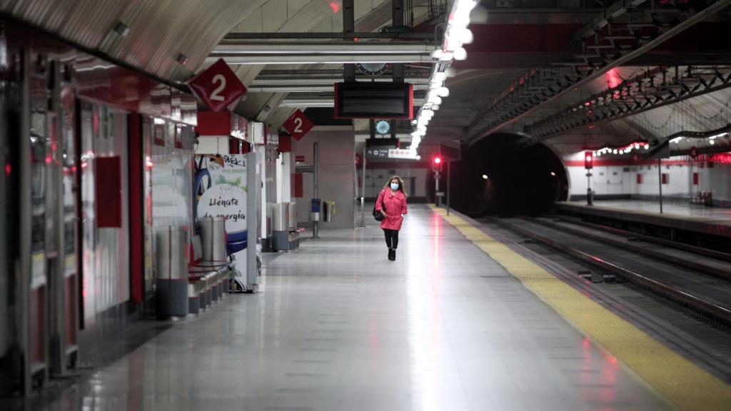 Una mujer con mascarilla en un andén de la estación de cercanías de Nuevos Ministerios .