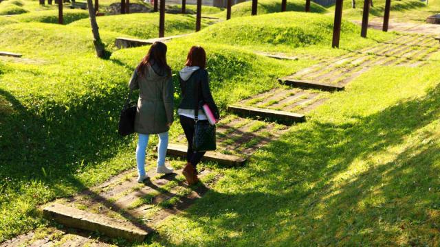 Dos estudiantes caminan por el campus de Elviña.