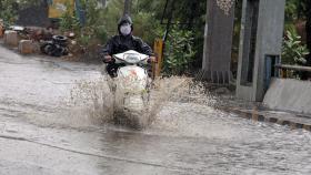 Una motocicleta atraviesa una balsa de agua tras las lluvias torrenciales. EFE/EPA Sanjeev Gupta