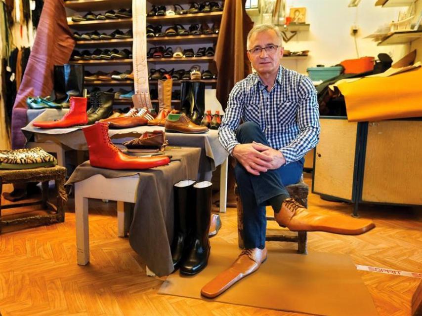 El zapatero rumano Grigore Lup posa con un par de zapatos que inventó durante la pandemia de Coronavirus.