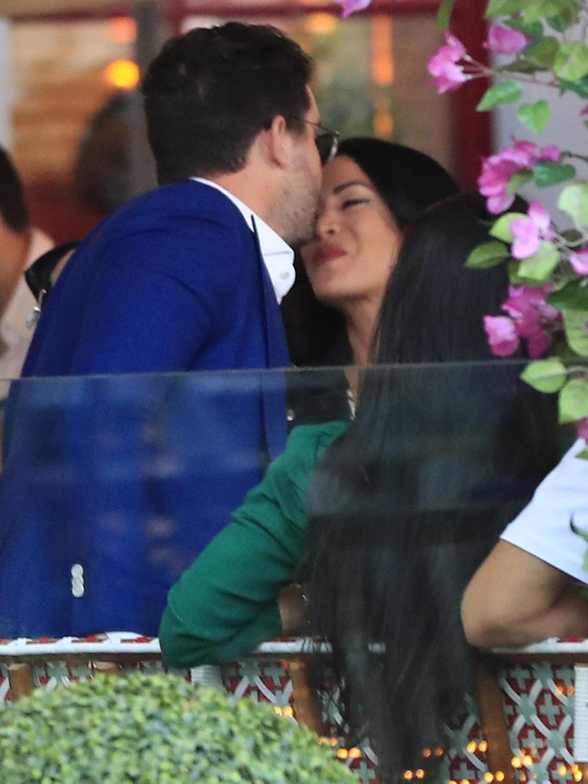 Alejandra se muestra feliz junto a Tassio, quien besa su frente para saludarla en una terraza.