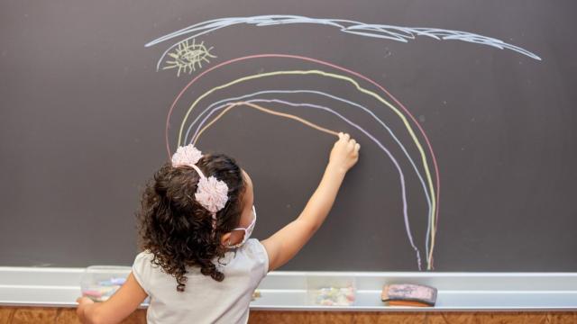 Una niña vuelve a utilizar la pizarra de clase tras el confinamiento.