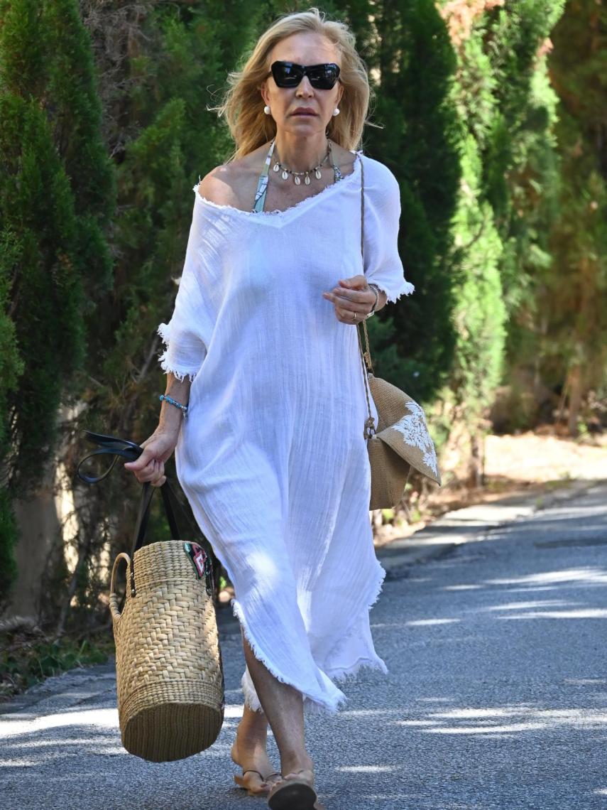 Carmen Lomana, con caftán blanco, camino a la playa en Marbella.