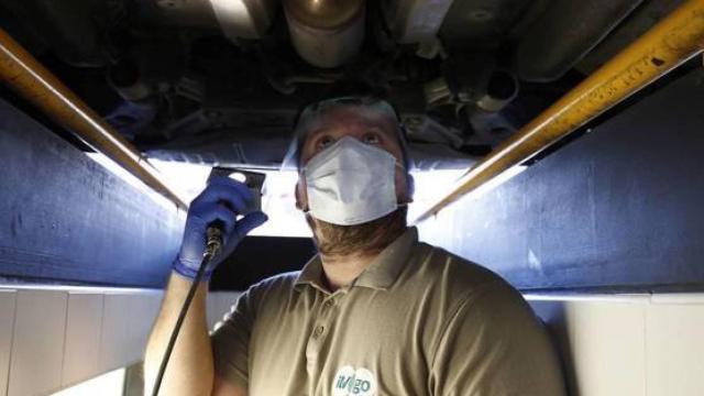 Un operario revisa un coche en la ITV con mascarilla.