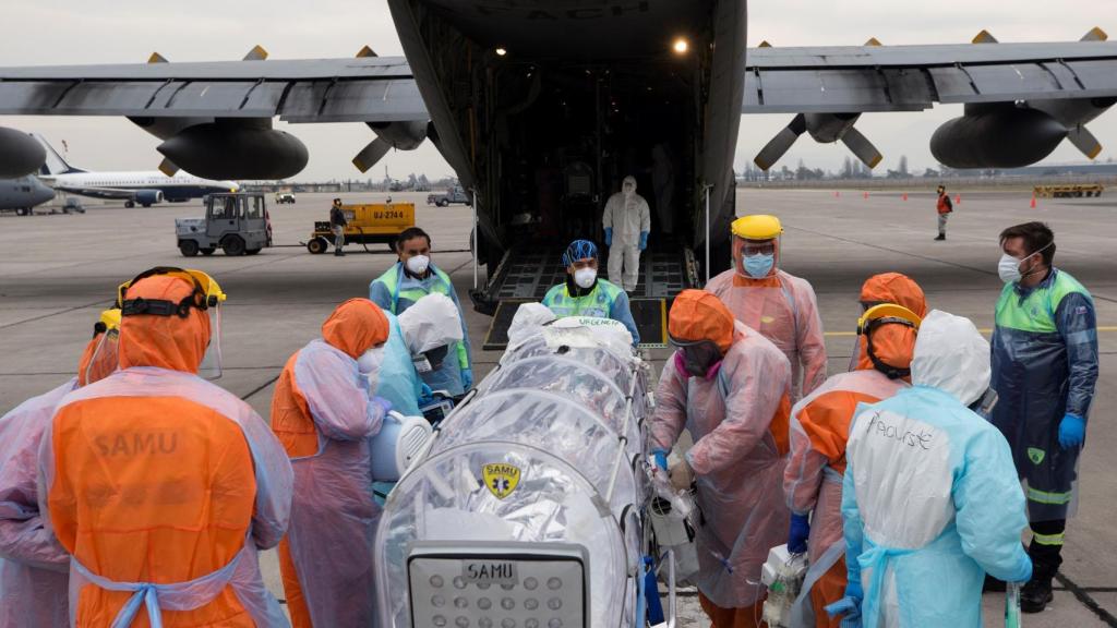 Personal sanitario de la Fuerza Aérea de Chile llevan a un avión a un paciente crítico