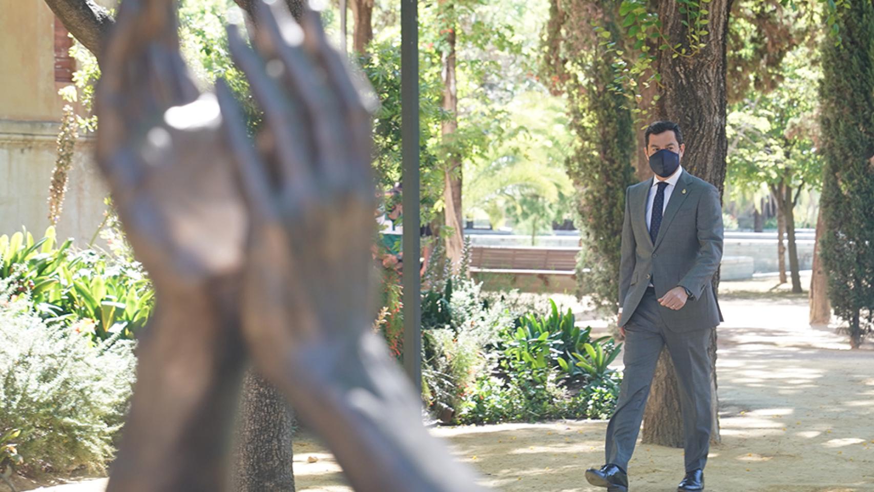 El presidente de la Junta de Andalucía, Juanma Moreno, ante la escultura en homenaje por la lucha contra el Covid.