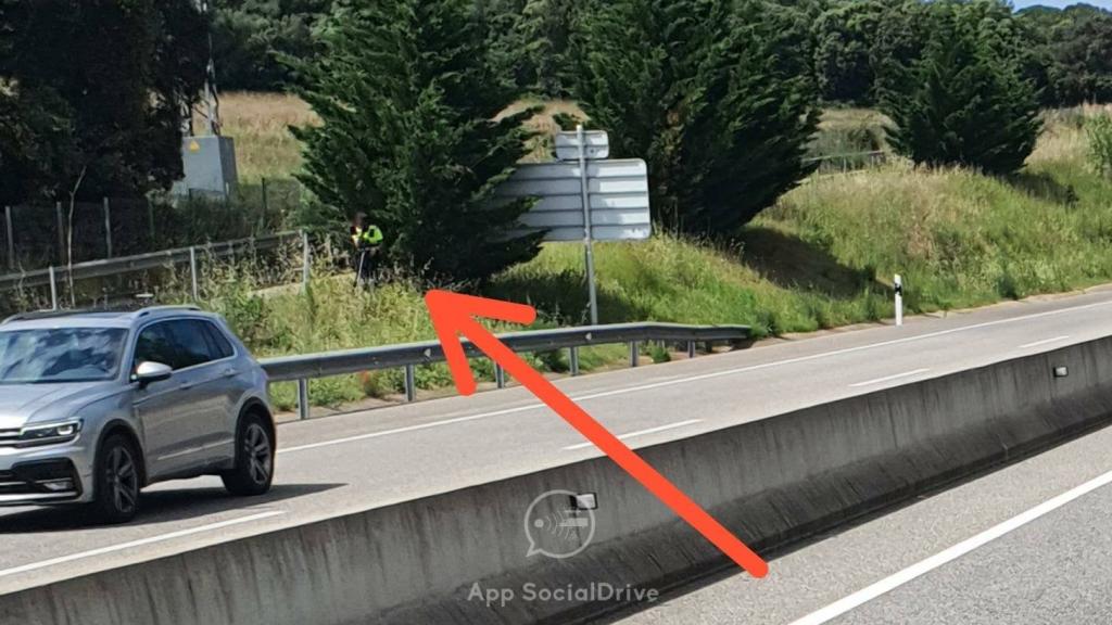 Un agente escondido tras un árbol con lo que parece un radar láser.