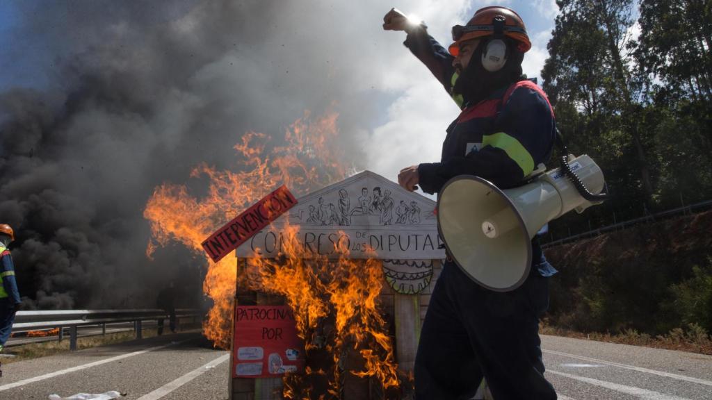 Un trabajador del comité de empresa de Alcoa levanta el brazo como signo de protesta en la concentración realizada en la A8.