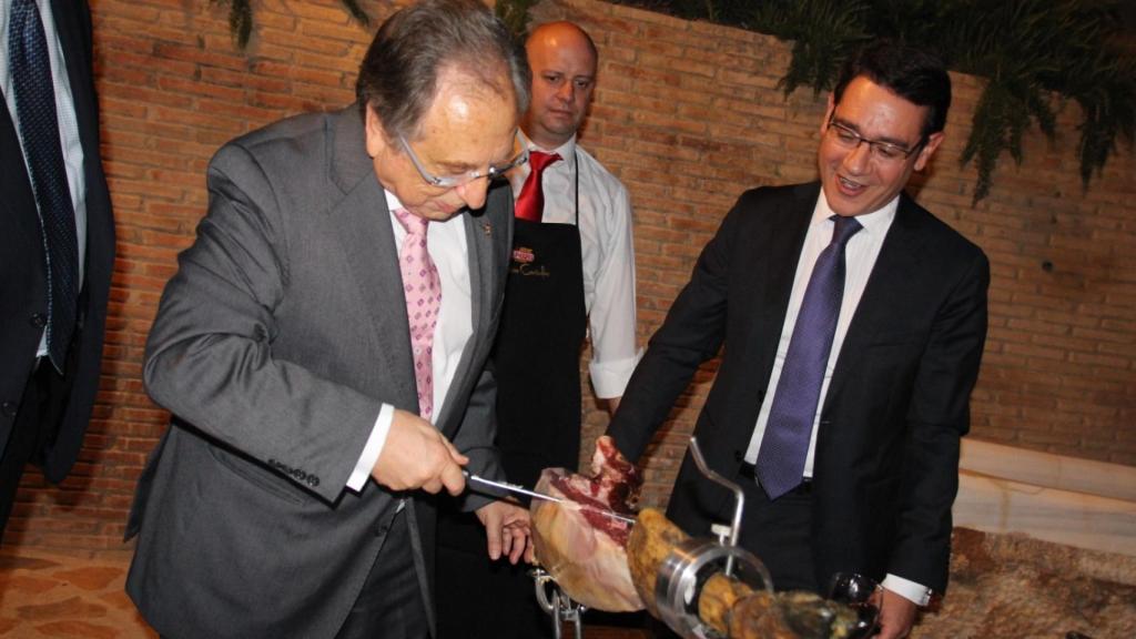 Tomás Fuertes, cortando jamón junto al entonces miembro del Gobierno regional, José Gabriel Ruiz.