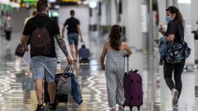 Viajeros ataviados con mascarillas a su llegada al Aeropuerto de Palma de Mallorca.