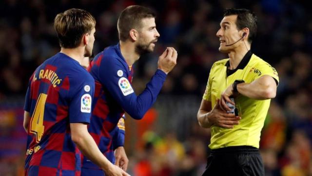 Gerard Piqué e Ivan Rakitic protestan a Juan Martínez Munuera en un partido del Barça en el Camp Nou