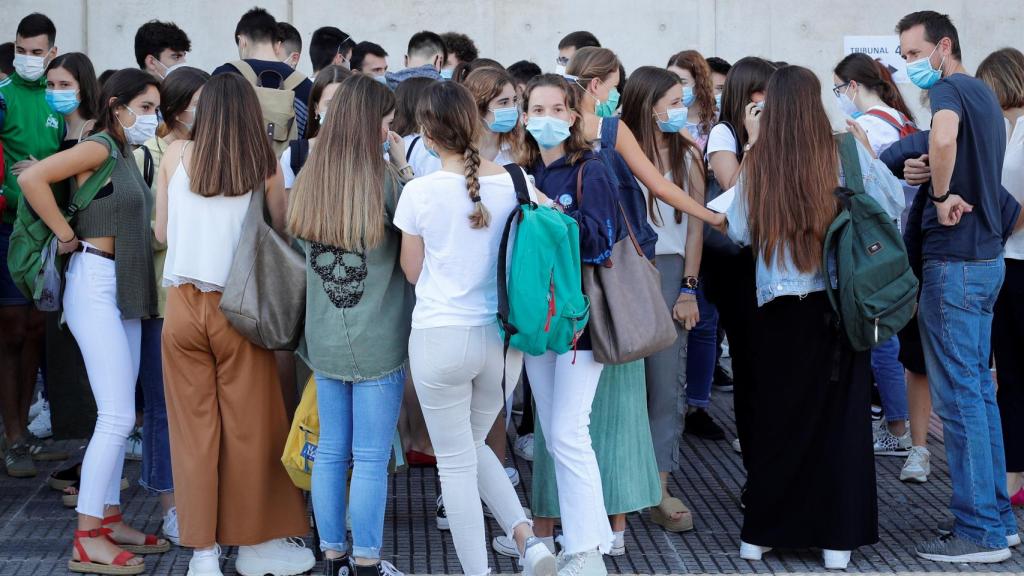 Varios alumnos, con mascarilla, se agolpan a la entrada de la Universidad.