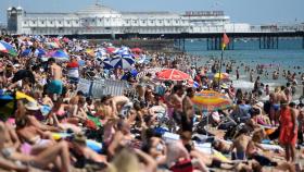 Cientos de personas disfrutan de una calurosa jornada en la playa en Brighton (Reino Unido), este jueves.