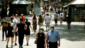 Paseantes por Las Ramblas de Barcelona con mascarilla. EFE/Toni Albir