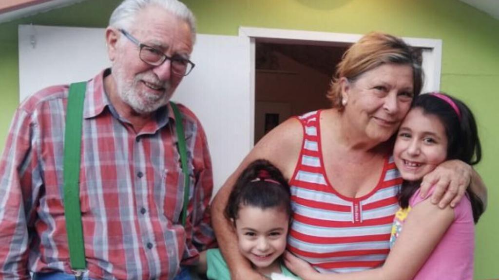 Ricardo y Mercedes con sus nietas delante de la casa que les han construido.