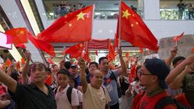 Un grupo de simpatizantes de China muestra banderas y cantan consignas en Amoy Plaza en Hong Kong (China). Efe