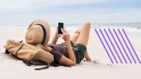 Una chica en la playa con su teléfono.