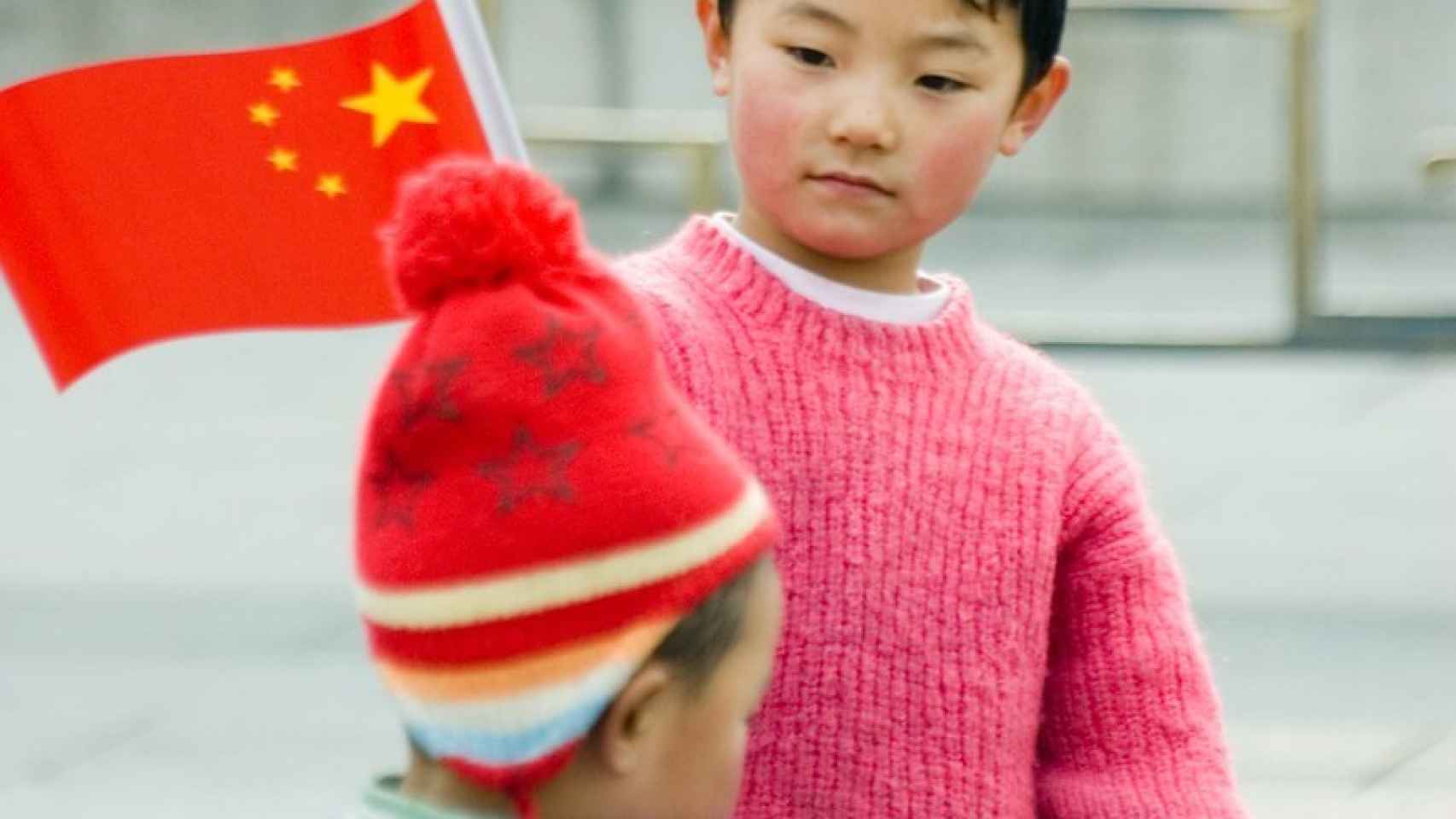 Un niño sostiene una bandera de China en Pekín.