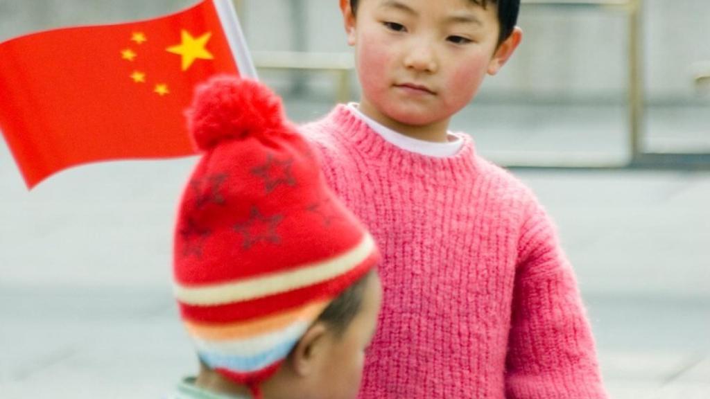 Un menor pasea con su familia en el centro de Pekín.
