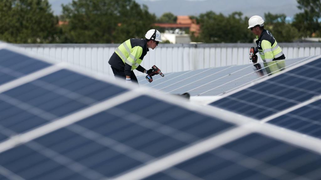 Unos trabajadores instalando paneles solares.