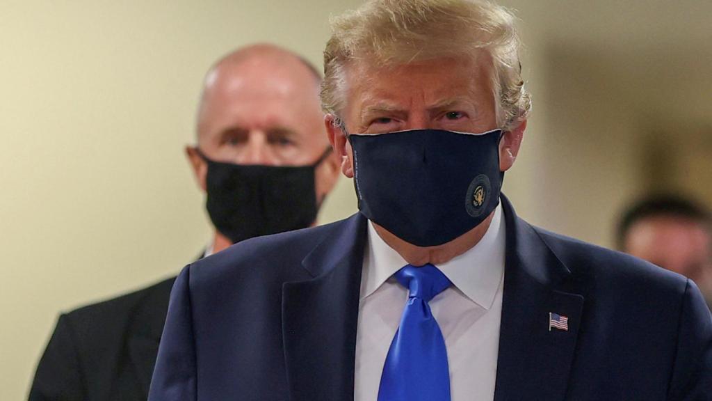 Donald Trump, con mascarilla, camina por los pasillos del hospital militar Walter Reed, en las afueras de Washington.
