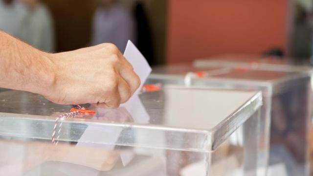 Unrecognizable person putting paper in sealed  transparent box, voting for elections, shallow doff