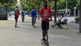 Jóvenes pasean en bicicleta y en patinete este martes en el barrio de Cap Pont, Lleida.