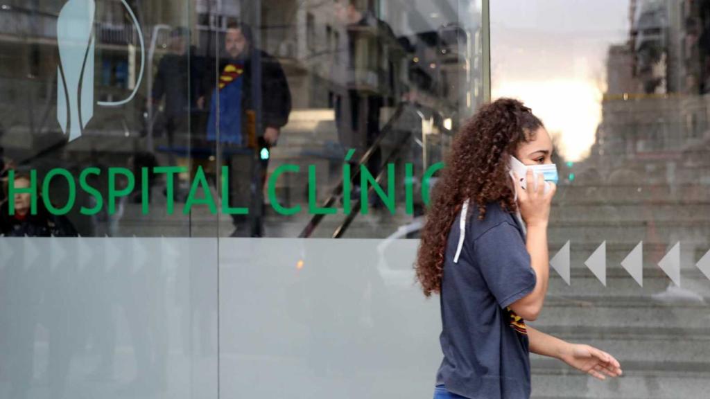 Una joven con mascarilla en la puerta del Hospital Clinic.