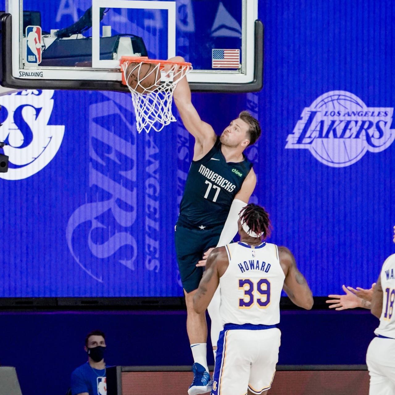 Luka Doncic machaca el balón en el aro de uno de los pabellones de la burbuja de Orlando en la cara de Dwight Howard