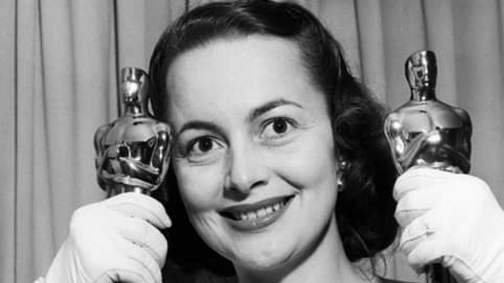 Olivia de Havilland sostiene dos premios Oscar.